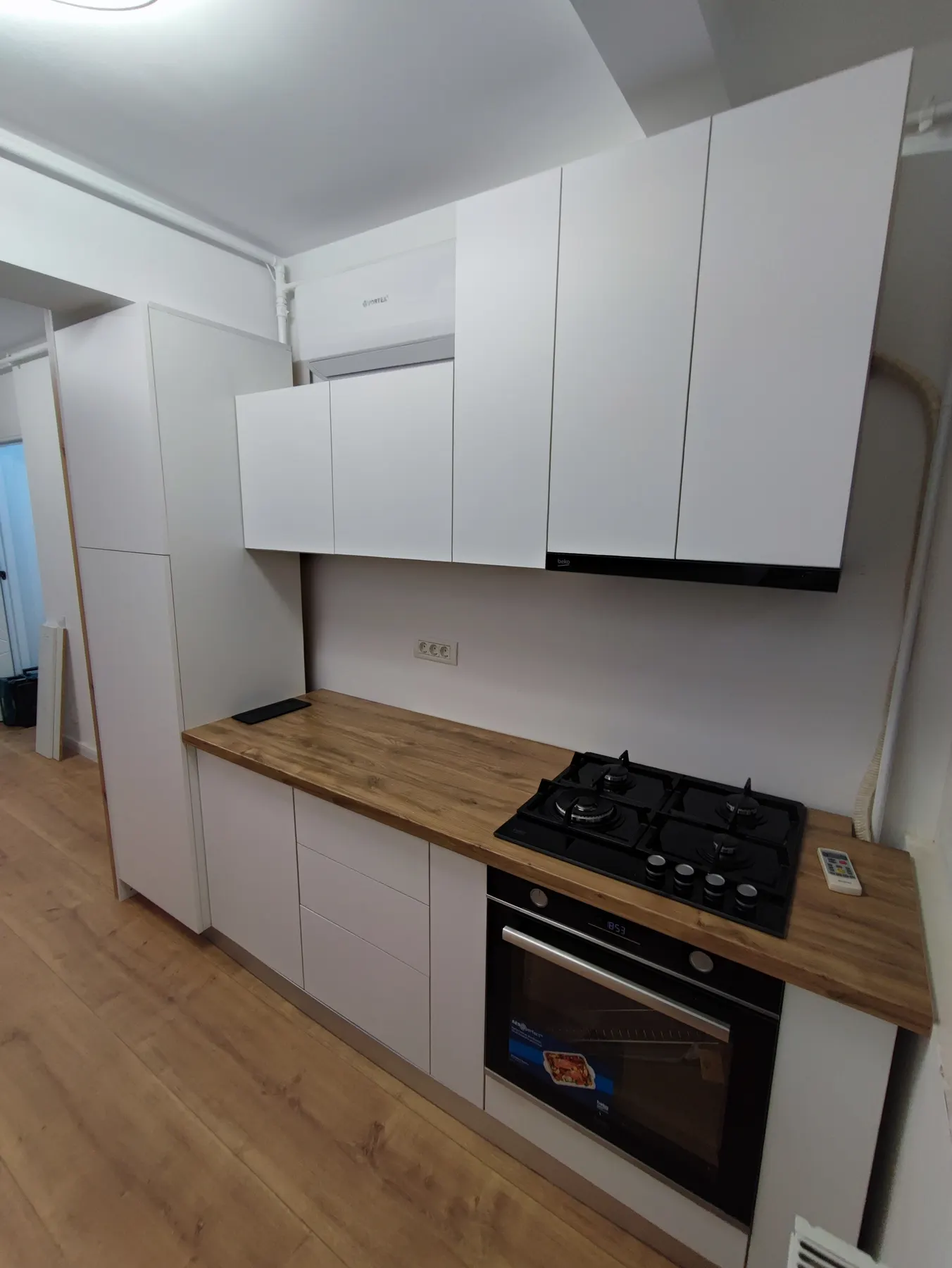 Bucătărie cu fronturi MDF vopsit alb mat și panou riflat din nuc — exemplu de combinație MDF + lemn masiv